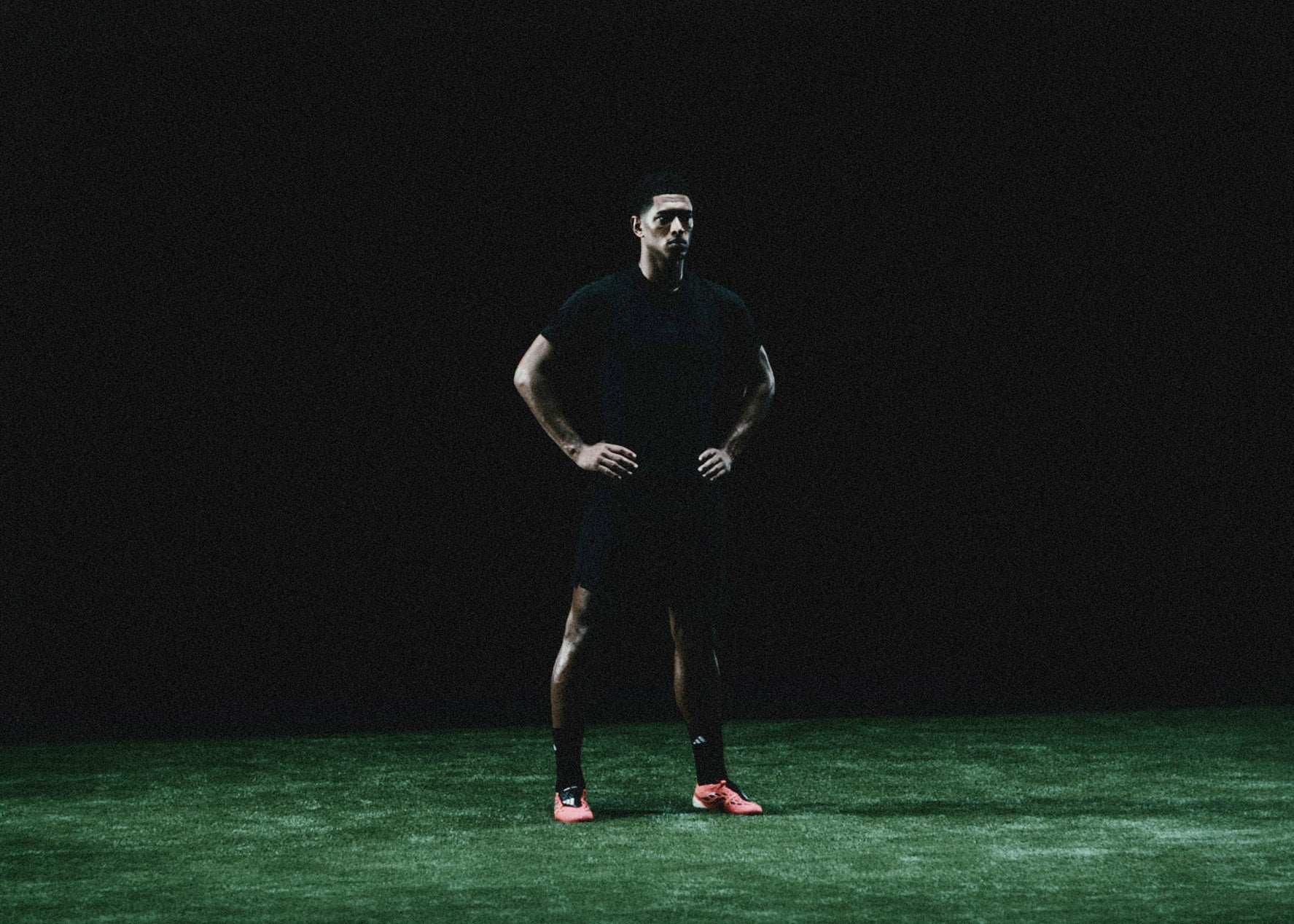 Jude Bellingham standing on a pitch under studio light