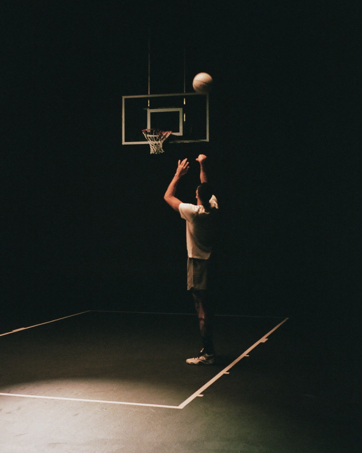 Jayson Tatum shooting under a single spotlight